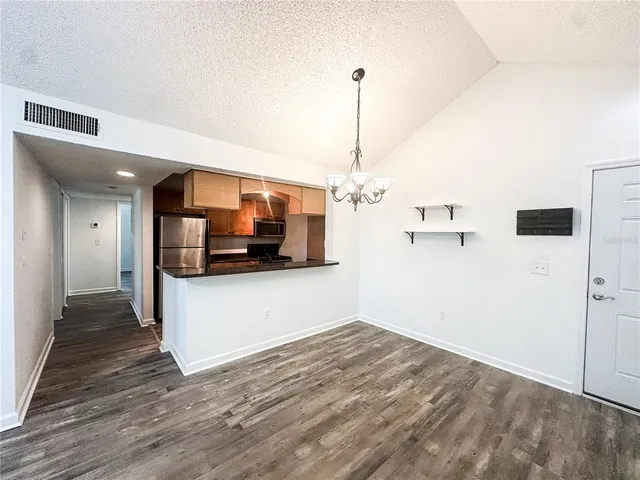 a view of a kitchen with a sink and an empty room