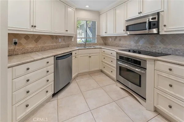 a kitchen with cabinets stainless steel appliances and sink