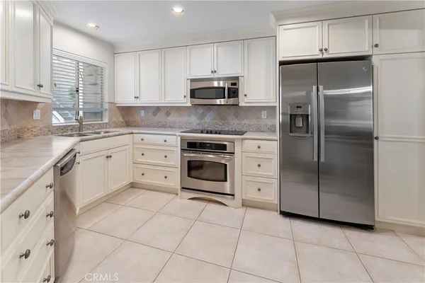 a kitchen with cabinets stainless steel appliances and a counter space