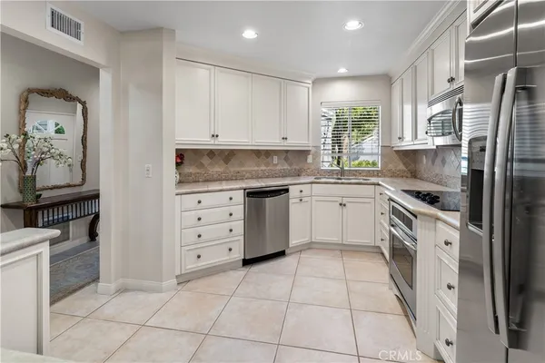 a kitchen with white cabinets and white appliances