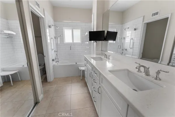 a large white kitchen with a double vanity sink and a mirror