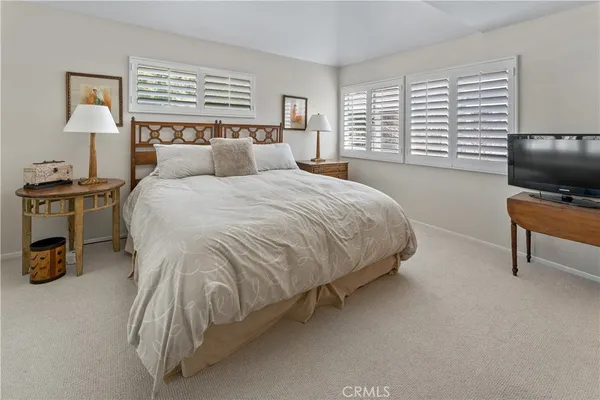 a bedroom with a bed and a tv on table