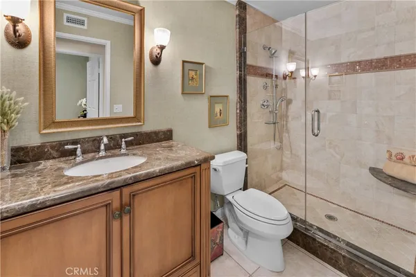 a bathroom with a granite countertop sink toilet mirror and shower