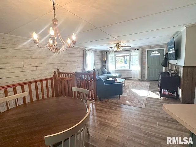 a living room with furniture floor to ceiling window and wooden floor