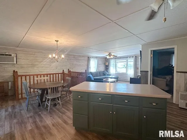 a dining hall with granite countertop a sink dishwasher a dining table and chairs with wooden floor