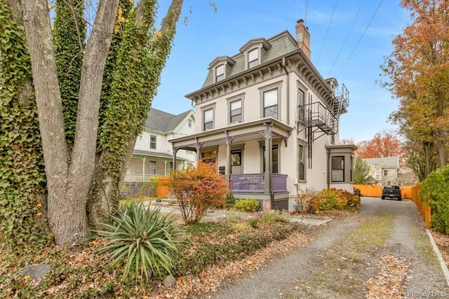 a view of a white building among the street with palm trees
