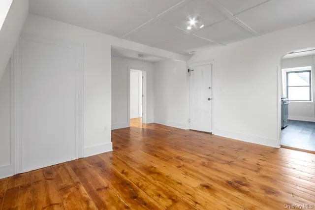 a view of an empty room and wooden floor