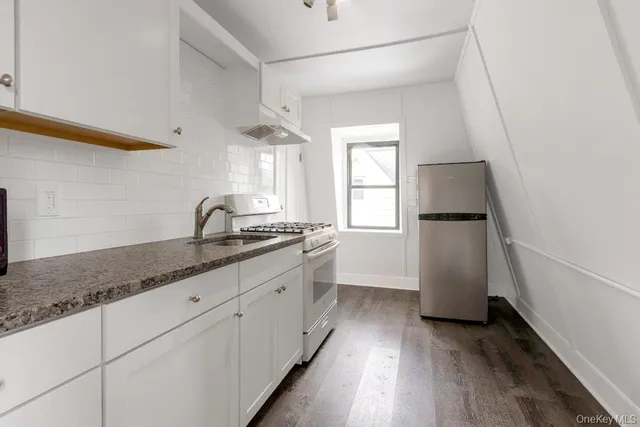a kitchen with granite countertop a refrigerator and a sink