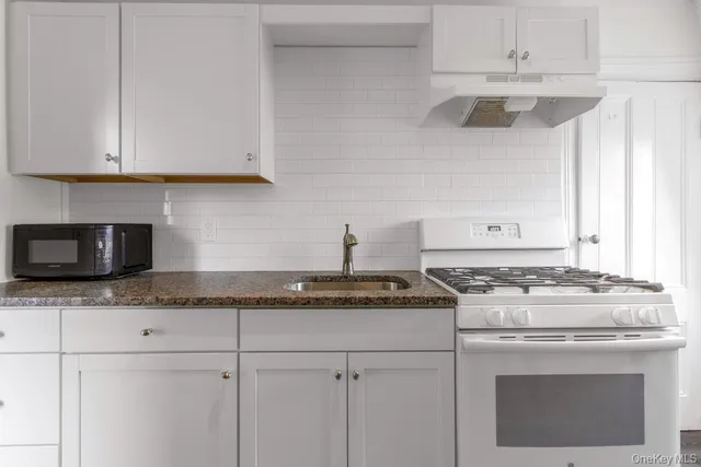 a stove top oven sitting inside of a kitchen