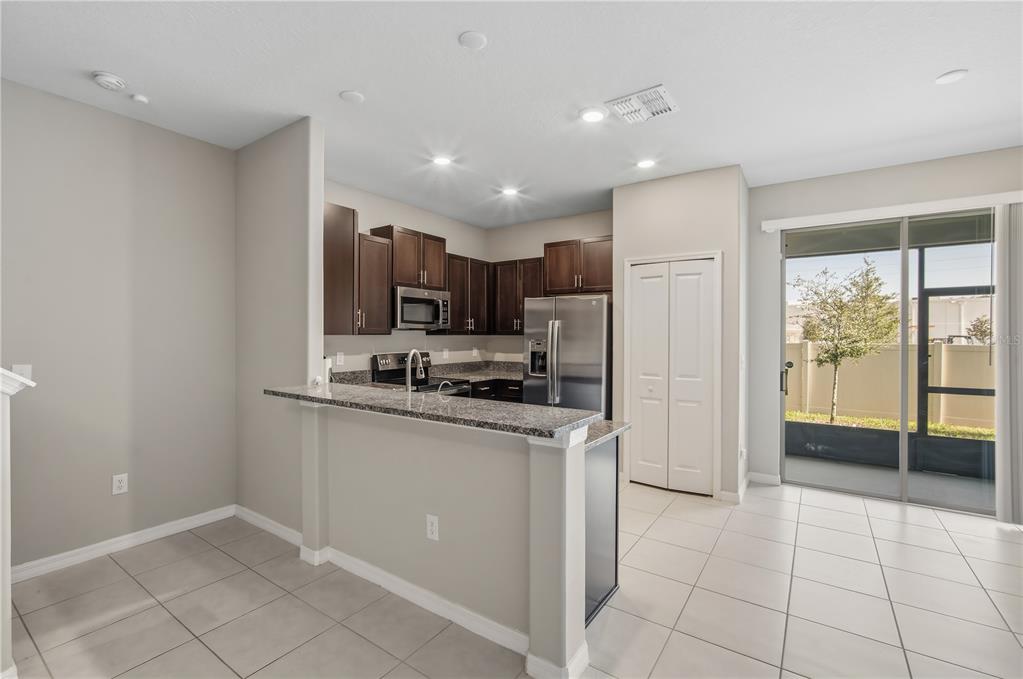 14316 Easy Goer Street Sun City Center, FL 33573 - Photo 11 of 26 a kitchen with stainless steel appliances granite countertop a refrigerator and a sink