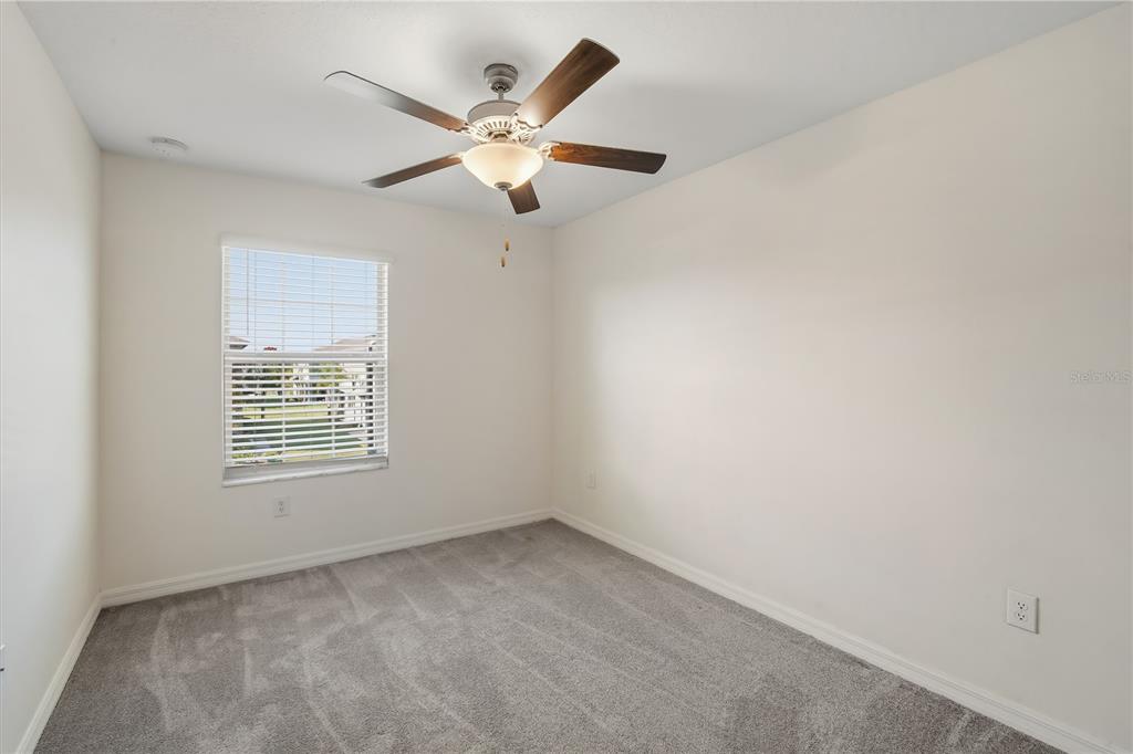 14316 Easy Goer Street Sun City Center, FL 33573 - Photo 15 of 26 an empty room with a window and a fan