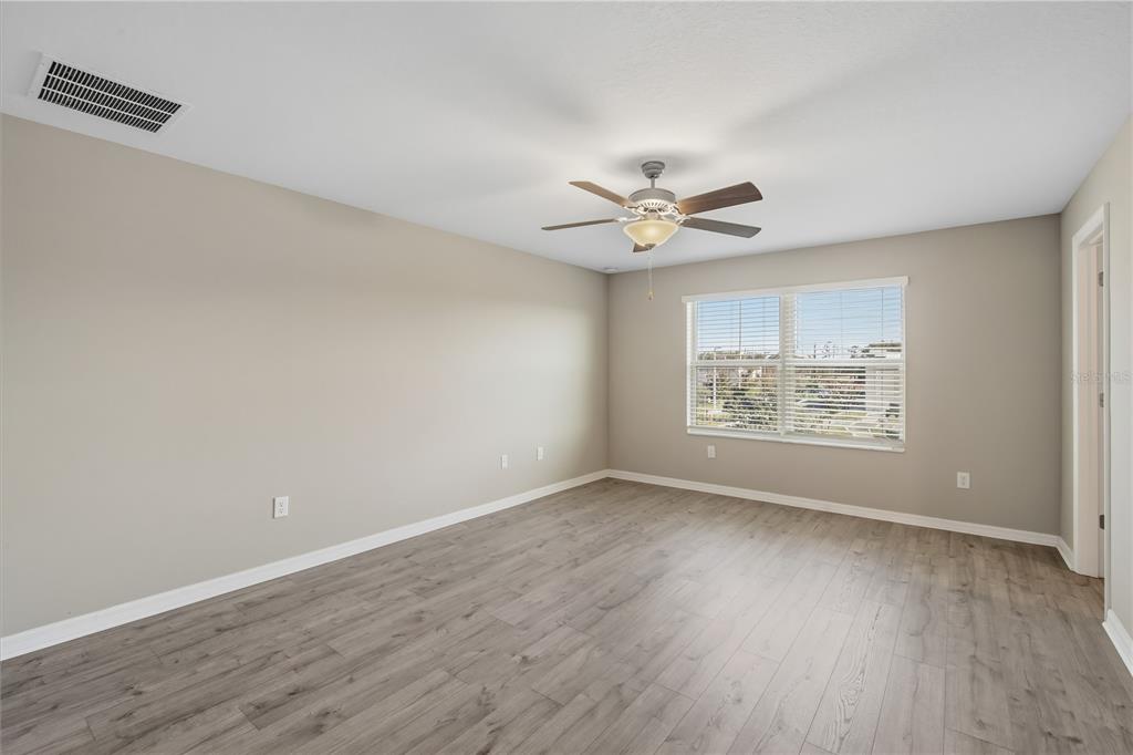 14316 Easy Goer Street Sun City Center, FL 33573 - Photo 18 of 26 an empty room with wooden floor and windows