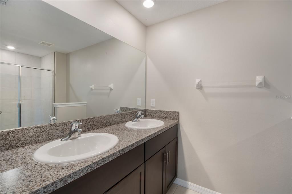 14316 Easy Goer Street Sun City Center, FL 33573 - Photo 20 of 26 a bathroom with a granite countertop sink and a mirror
