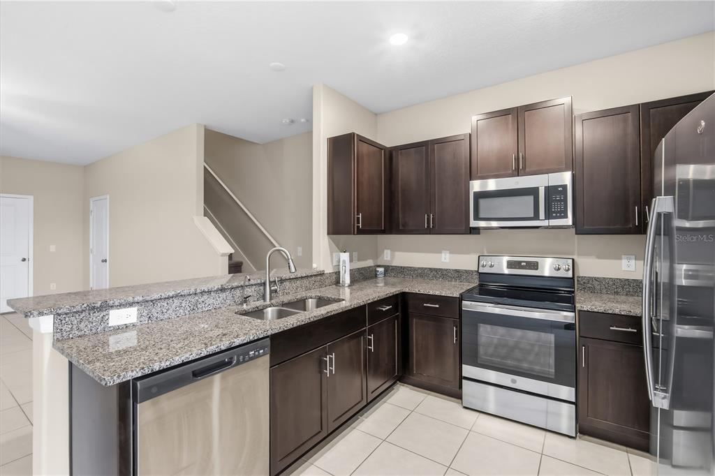 14316 Easy Goer Street Sun City Center, FL 33573 - Photo 4 of 26 a kitchen with a sink stove and microwave