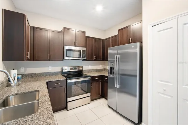 a kitchen with granite countertop a refrigerator and a sink