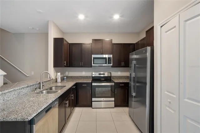 a kitchen with stainless steel appliances granite countertop a refrigerator and a sink
