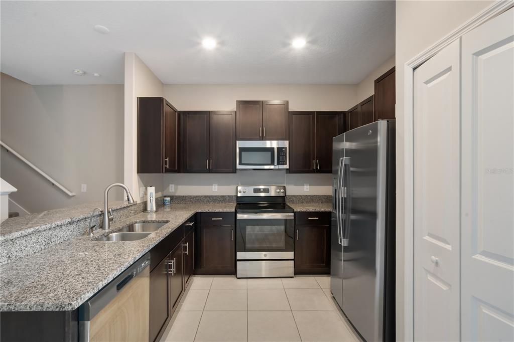 14316 Easy Goer Street Sun City Center, FL 33573 - Photo 6 of 26 a kitchen with stainless steel appliances granite countertop a refrigerator and a sink