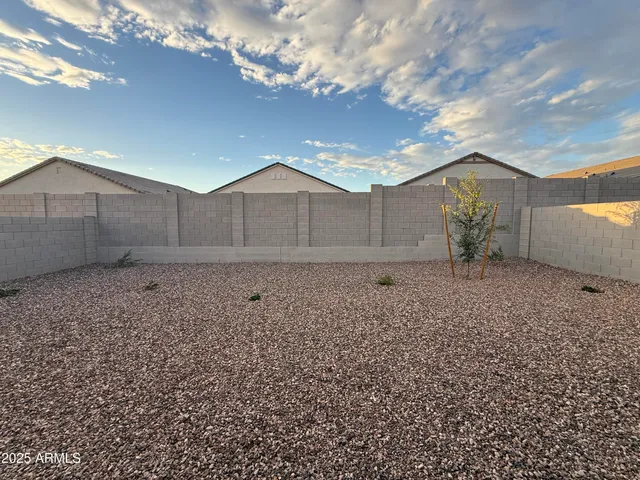 a front view of a house with a garden and lake view