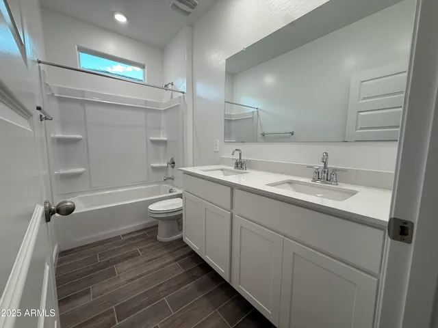 a spacious bathroom with a granite countertop sink a toilet and shower
