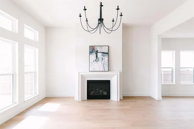 a view of an empty room with a fireplace and a window
