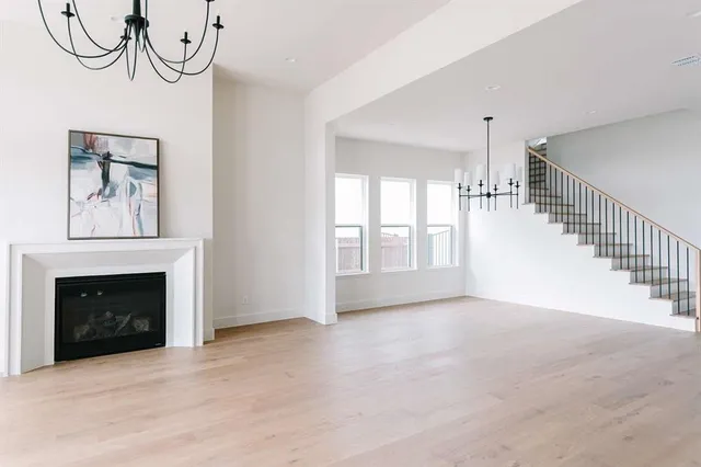 a view of empty room with fireplace and wooden floor