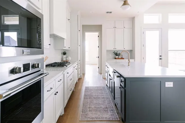 a kitchen with granite countertop a sink stove and cabinets