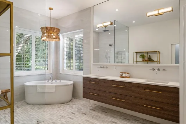a spacious bathroom with a tub sink and mirror