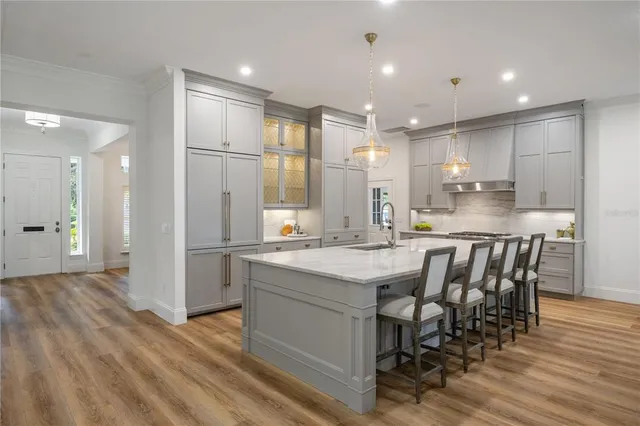 a kitchen with stainless steel appliances granite countertop a table chairs sink refrigerator and microwave