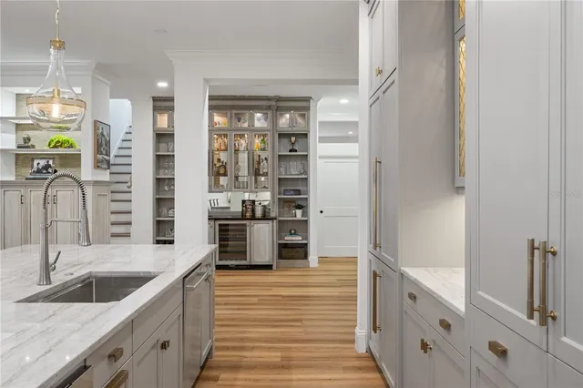 a kitchen with stainless steel appliances kitchen island granite countertop a refrigerator a sink and white cabinets