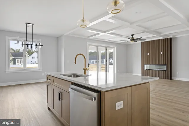 a kitchen with stainless steel appliances granite countertop a refrigerator a sink dishwasher a stove and white cabinets with wooden floor