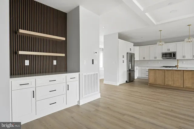 a view of a room with a chandelier and wooden floor