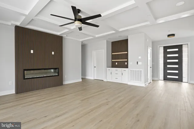 a view of a hallway with wooden floor and cabinets