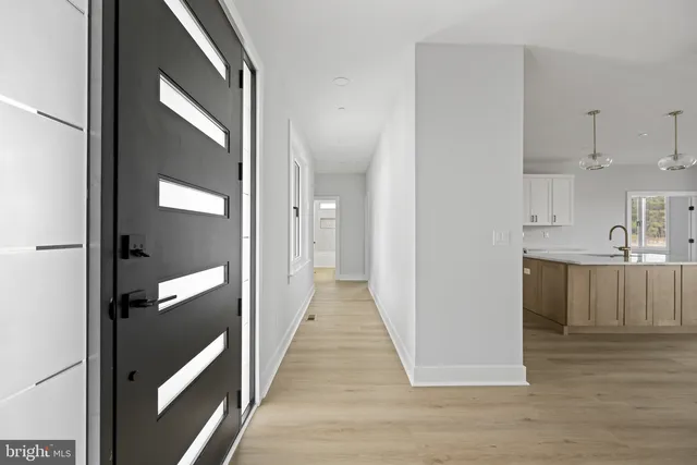 an empty room with wooden floor ceiling fan and windows