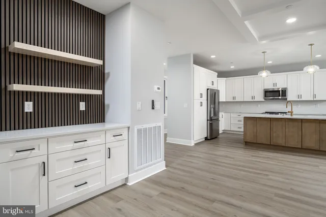 a kitchen with stainless steel appliances granite countertop a sink a stove and a wooden floors