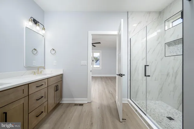 a kitchen with stainless steel appliances granite countertop a sink a stove and a wooden floors