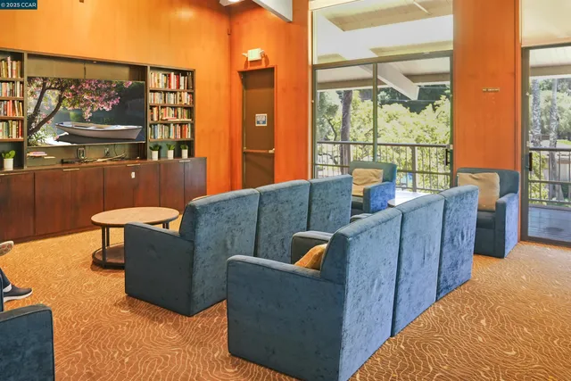 a room with wooden floor pool table and chairs