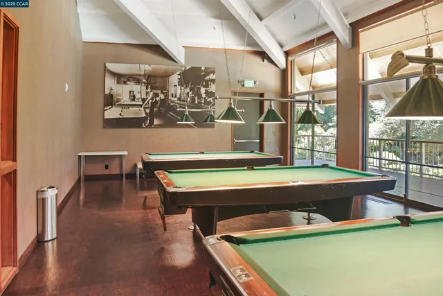 a room with pool table and chairs