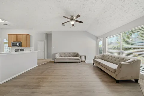 a living room with furniture and a kitchen