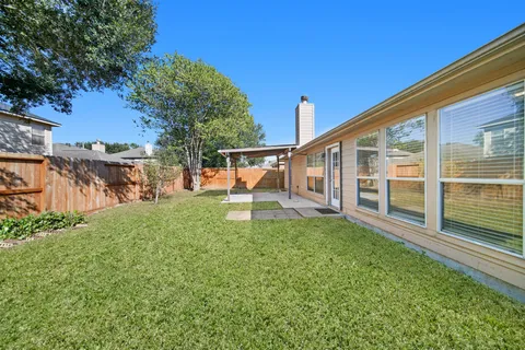 a view of a house with backyard and sitting area