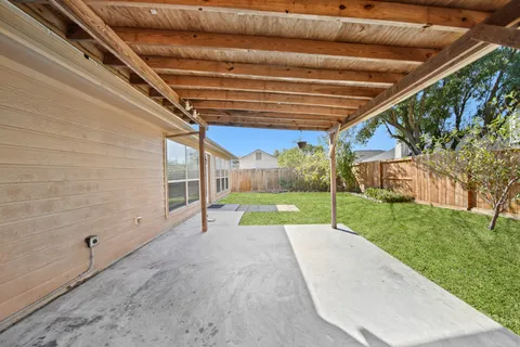 a view of a backyard with table and chairs under an umbrella