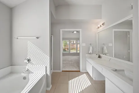 a bathroom with a tub sink and mirror