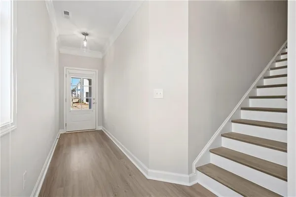 a view of a hallway with wooden floor and entryway