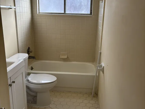 a white toilet sitting next to a bath tub