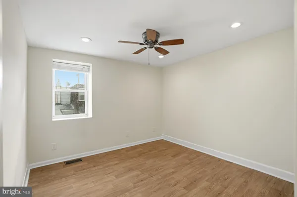 an empty room with a window and a ceiling fan