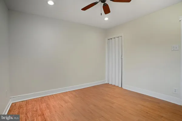 an empty room with ceiling fan and window