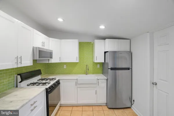 a kitchen with a refrigerator a stove and a cabinets