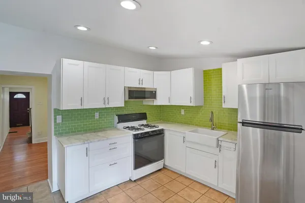 a kitchen with white cabinets and white appliances