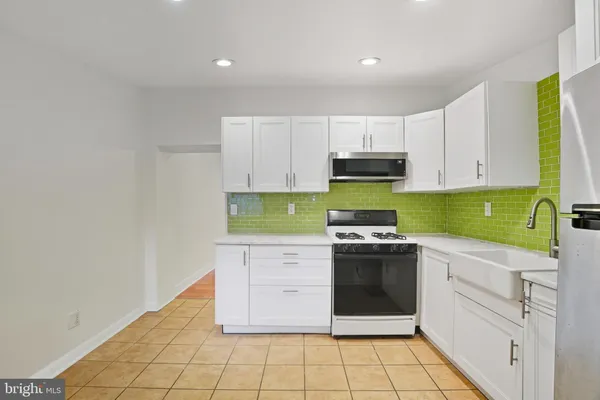 a kitchen with a stove sink and cabinets