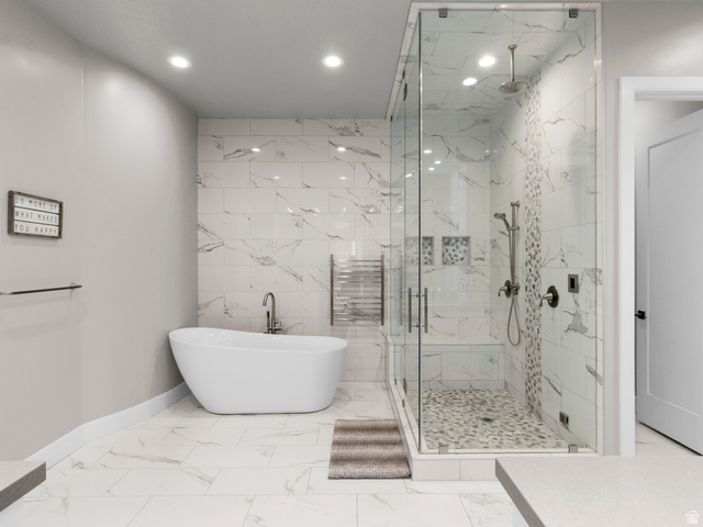 614 East High Lane Alpine, UT 84004 - Photo 40 of 75 Full bathroom with a soaking tub, a marble finish shower, recessed lighting, radiator heating unit, and tile walls