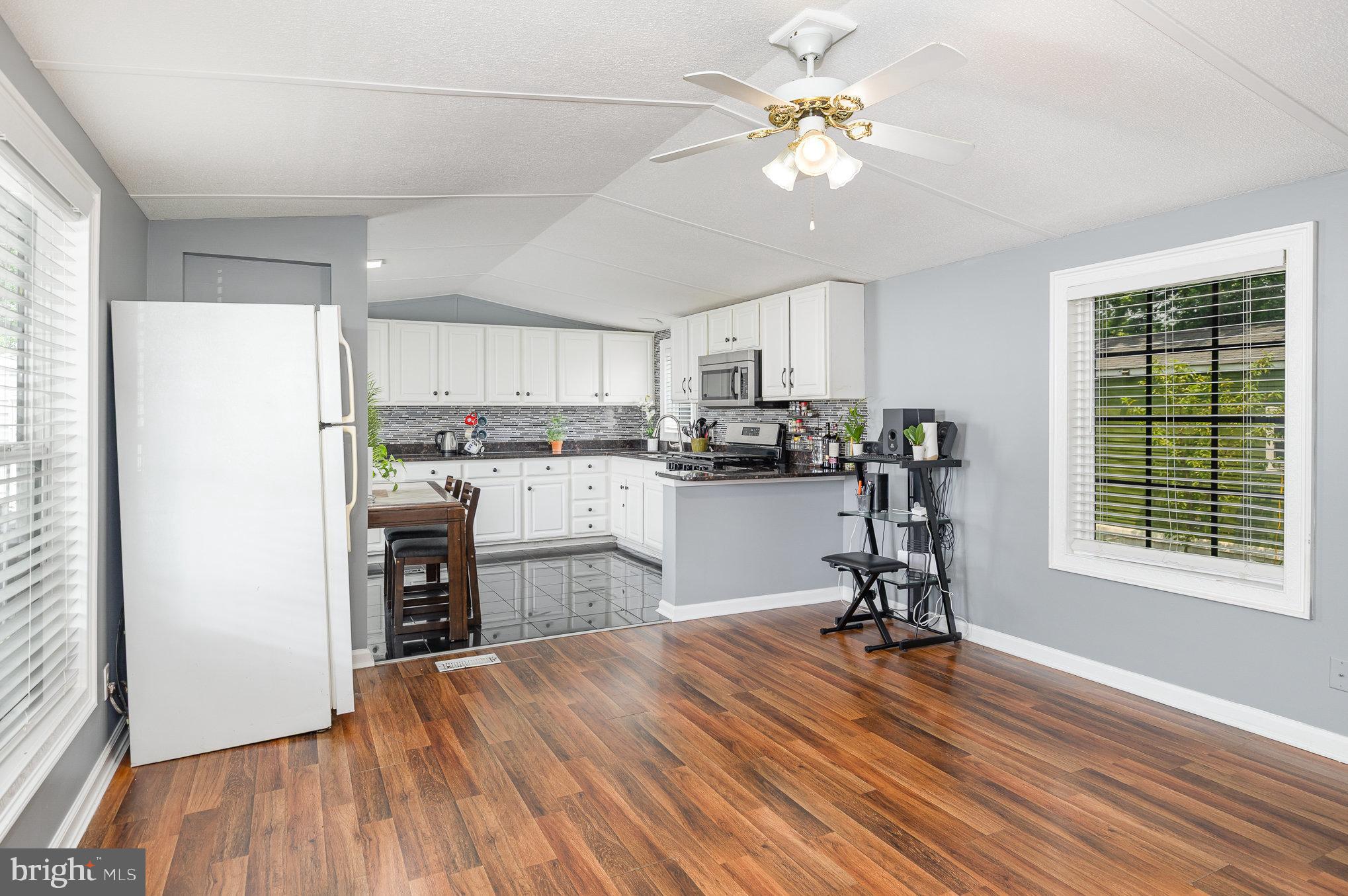 29 Renee Road Stafford, VA 22556 - Photo 8 of 24 a kitchen with kitchen island a stove a refrigerator cabinets a dining table and chairs with wooden floor